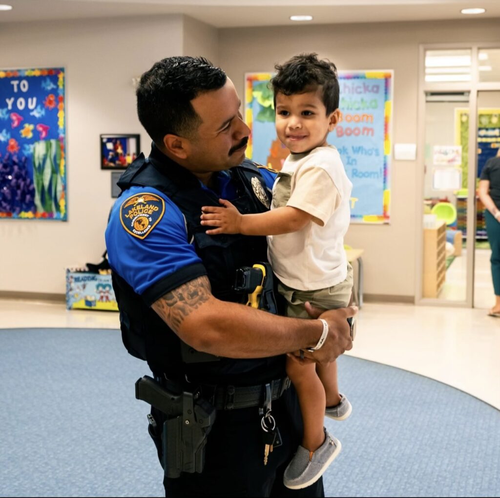 school resource officer holding little boy in classroom