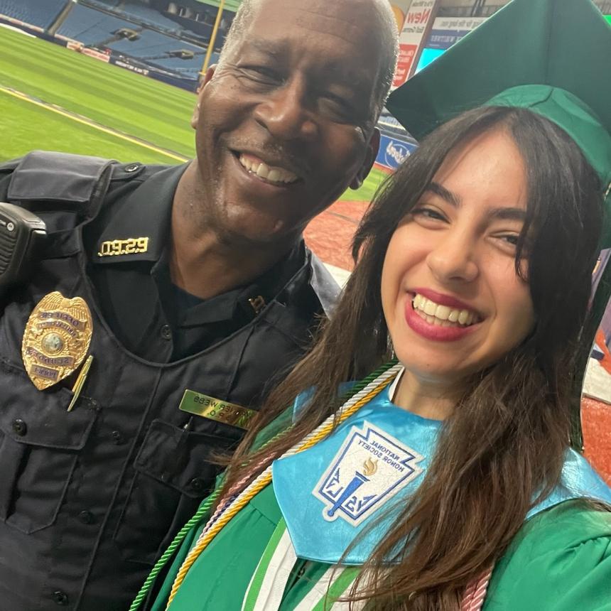 school resource officer and graduate taking selfie together - donate to scholarship