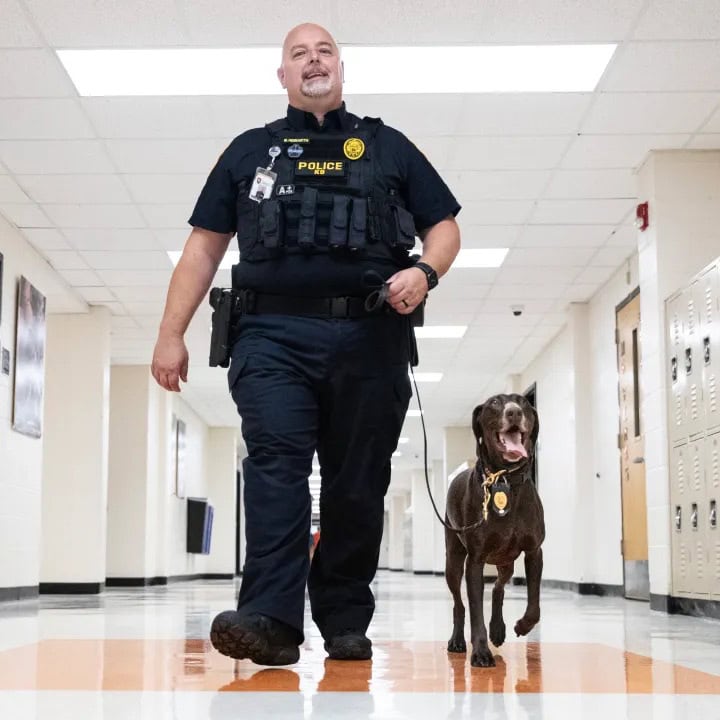 School Resource Officer walking school halls with canine