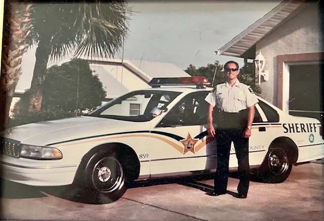 FASRO history - officer smiling by car in vintage photo